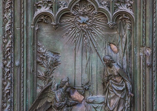 Detail of the carving on the door of the cathedral in Milan. In this picture, an angel has come with a message or gift to the person (Zachariah?) standing on the right. You can see God's presence in the form of the dove at the top.